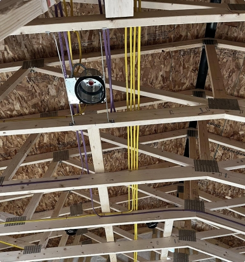 Residential home under construction — rough-in wiring and framing for new build or addition